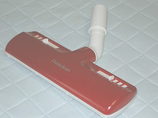 写真：布団に掃除機をかける