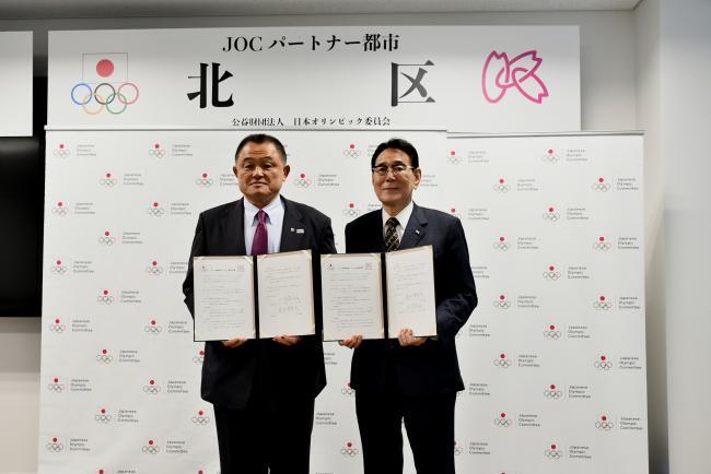 写真:協定書を持って記念撮影する関係者ら