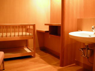 写真:ベビーベッドと手洗い場がある室内