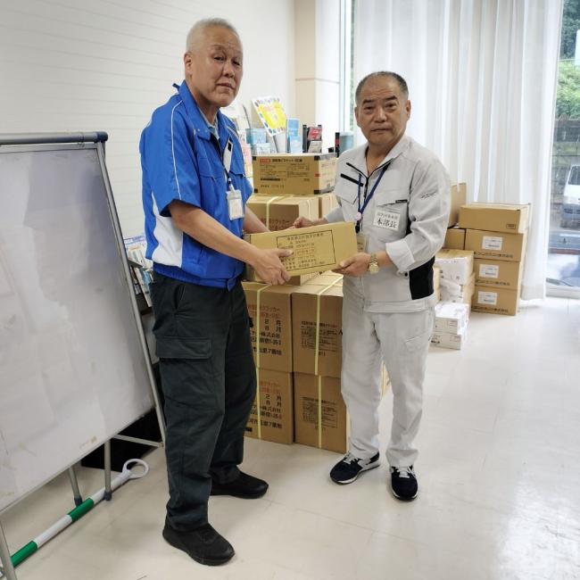 写真：加藤戸沢村長に物資を手渡す松田危機管理室長