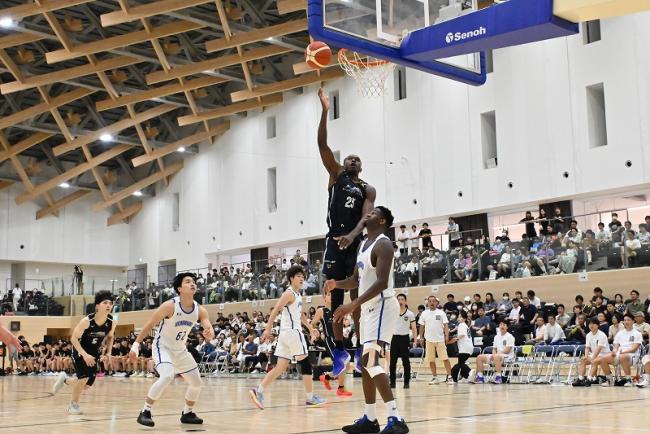 写真：シュートを決めるバスケットボール選手