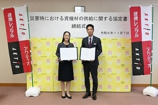 写真：協定書を手に持って記念撮影する区長と会社役員