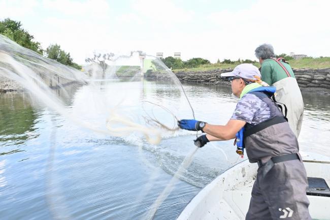 写真：投網をする会員