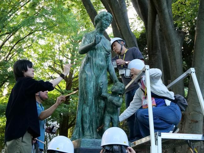 写真：銅像を洗剤で洗浄する人たち