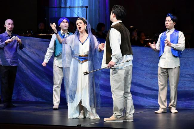 写真：歌う女性歌手を見る演者たち