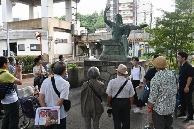 写真：長崎平和記念像の縮小レプリカの周りに集まる人々