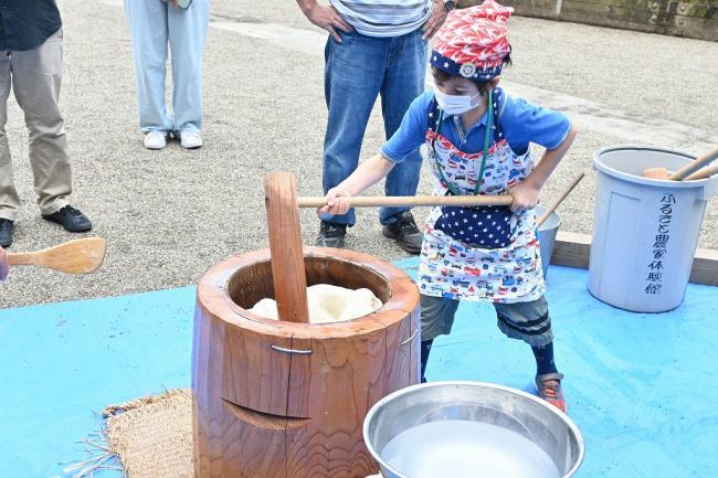 写真：杵と臼で団子の生地をつく児童