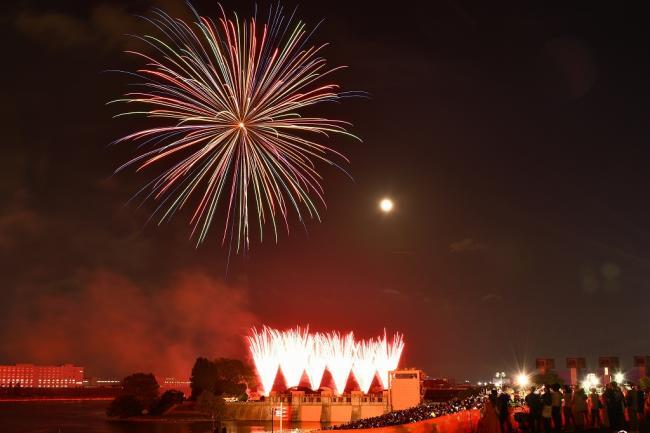 写真：大きな打ち上げ花火と地上から噴き出す花火