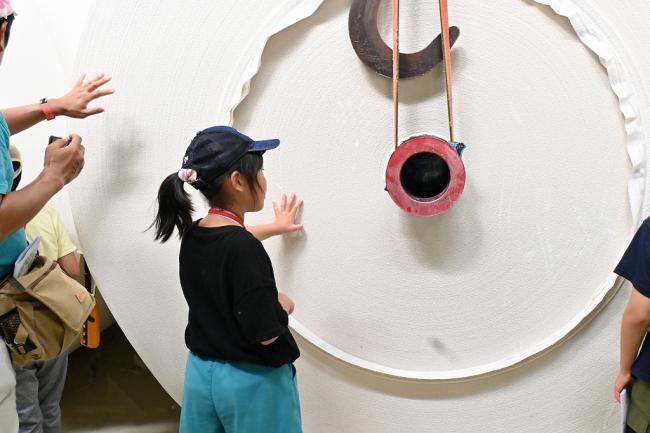 写真：再生紙のロールを触る児童