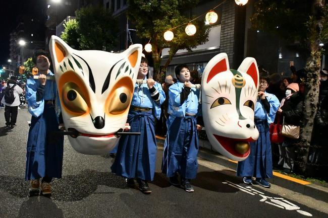 写真：巨大な狐の面を持って行進する人たち