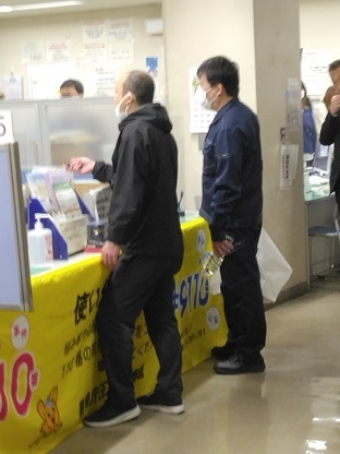 写真：窓口に刃物を出している犯人役の警察官