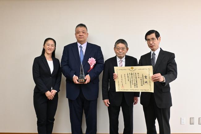 写真：表彰状を持って記念撮影する受賞者と区長と関係者ら