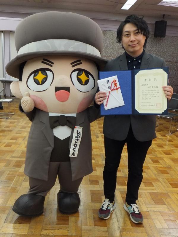 写真：しぶさわくんと記念撮影する受賞者