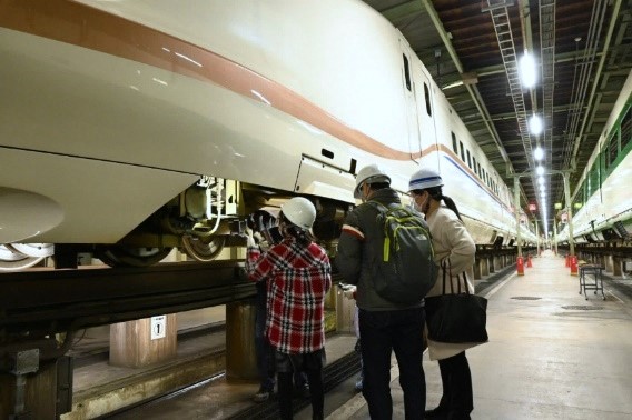 写真：新幹線E7系の台車を撮影する参加者