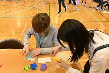 アメリカの中学生と北区の小学生が折り紙をする様子