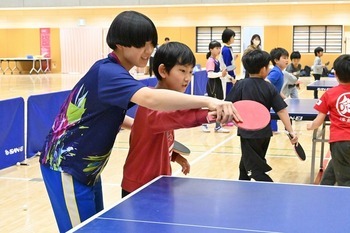 高校生が参加者にフォームを教えている様子