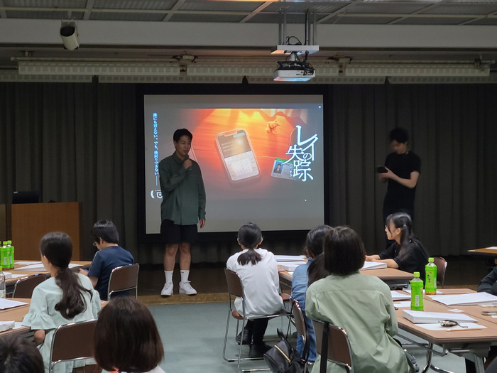 スクリーンの前で説明する画像