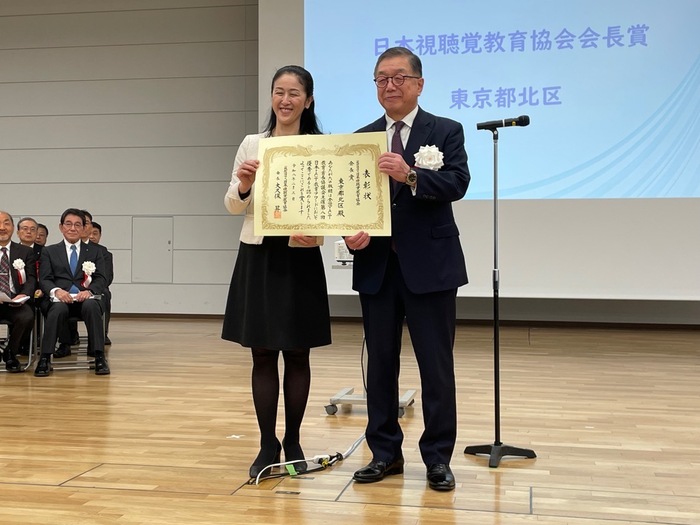 写真：日本視聴覚教育協会会長から表彰状を授与され、ともに笑顔で表彰状を持つ山田区長